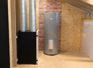 A water heater tank installed next to a heating system.