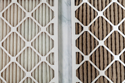 A clean HVAC air filter next to a dirty filter.